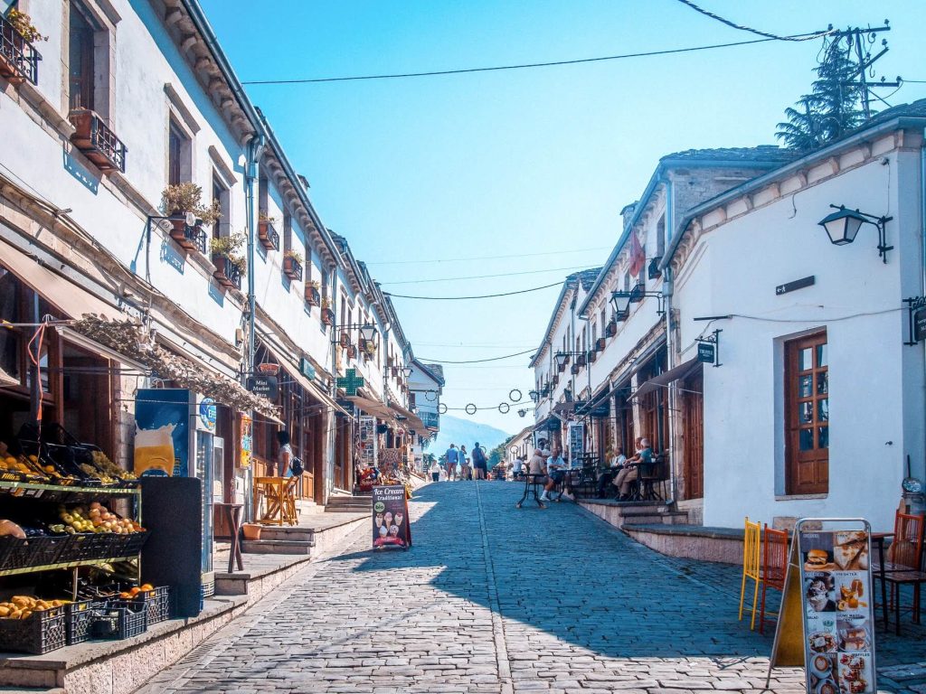 Gata med butiker och restauranger i Gjirokaster Albanien en solig dag på sommaren