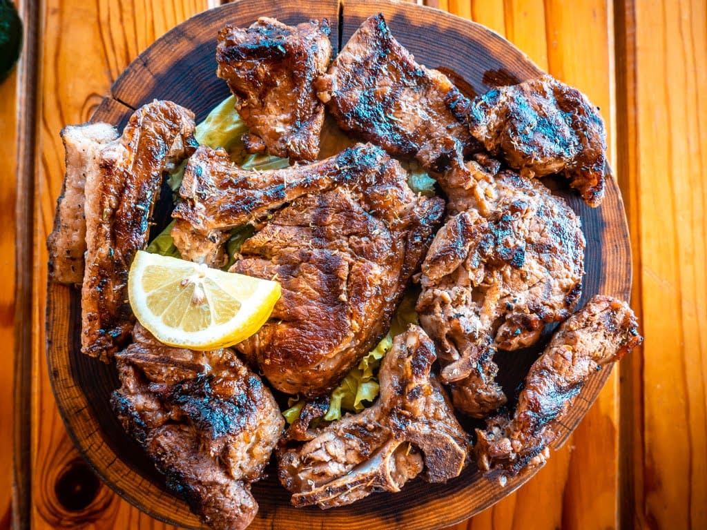 Tave Mishi – Albansk kötttallrik med olika köttsorter på en träbricka på en restaurang i Tirana